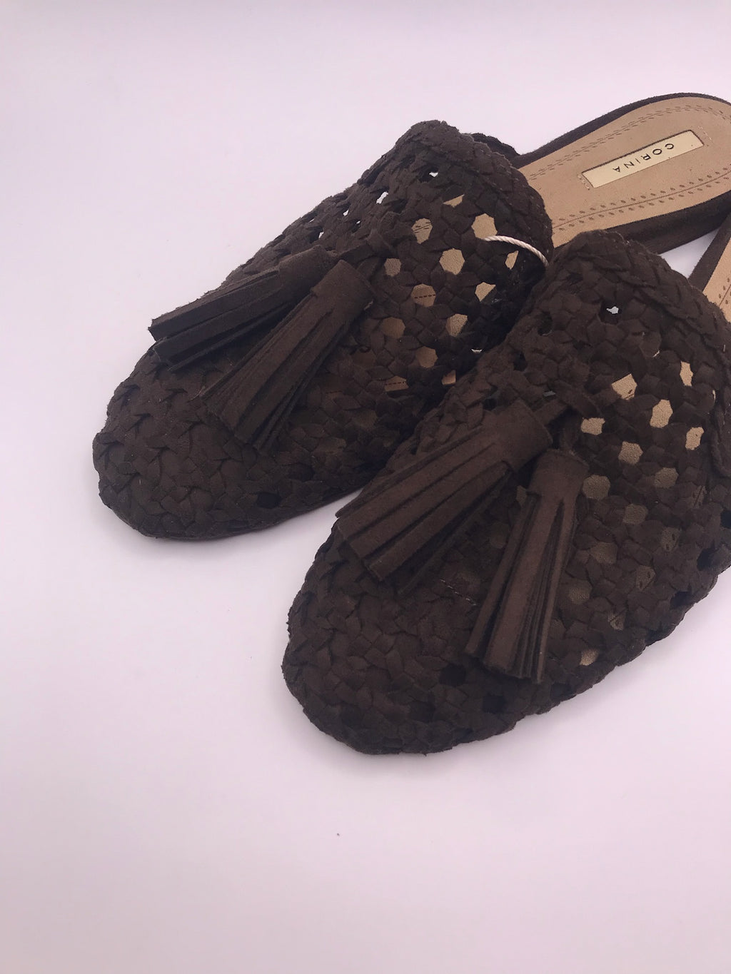 Mules Corina de senhora castanho escuro Cafe em camurça sintética trançada; sapatos rasos casuais, chinelos com detalhe de borlas franja e biqueira fina para o dia a dia