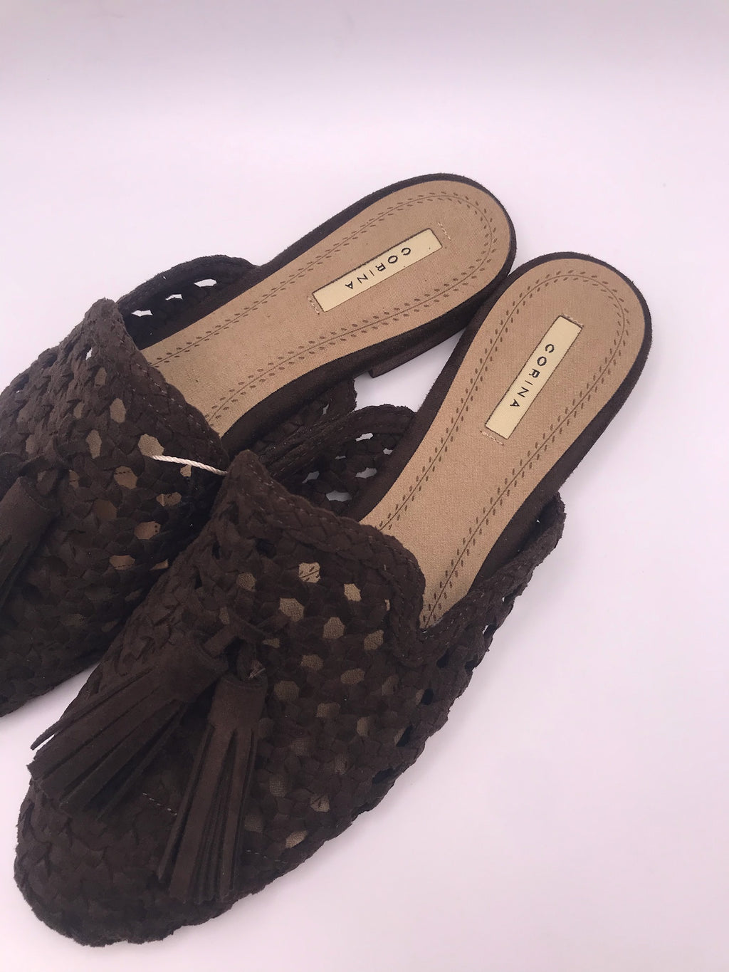 Mules Corina de senhora castanho escuro Cafe em camurça sintética trançada; sapatos rasos casuais, chinelos com detalhe de borlas franja e biqueira fina para o dia a dia