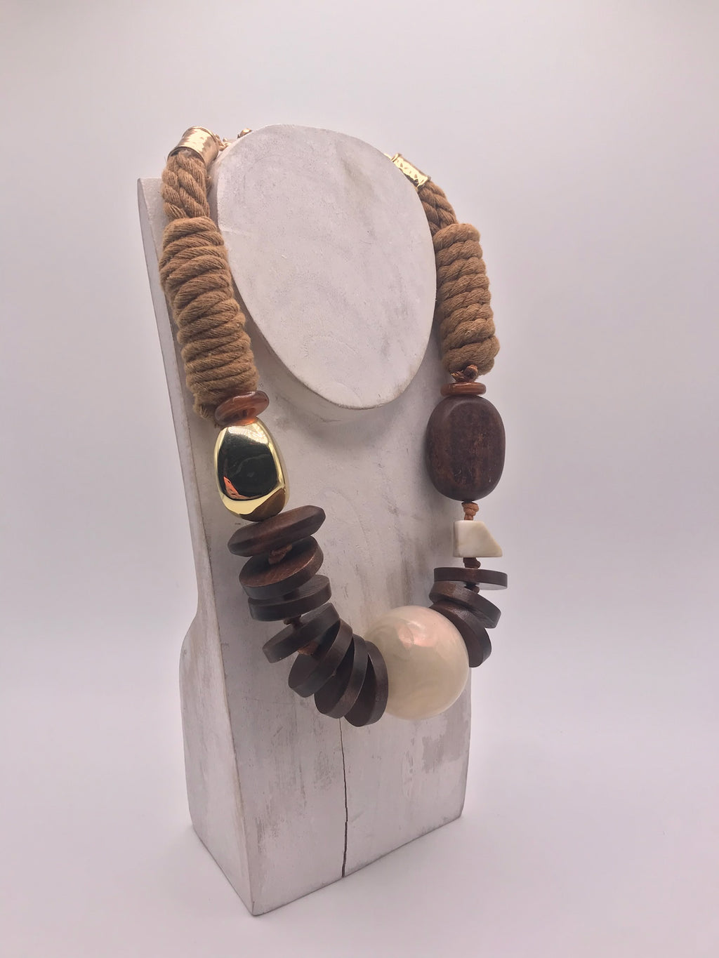 Colar artesanal de corda castanha e peças geométricas de madeira, bijuteria étnica boémia com esfera bege e detalhe dourado.