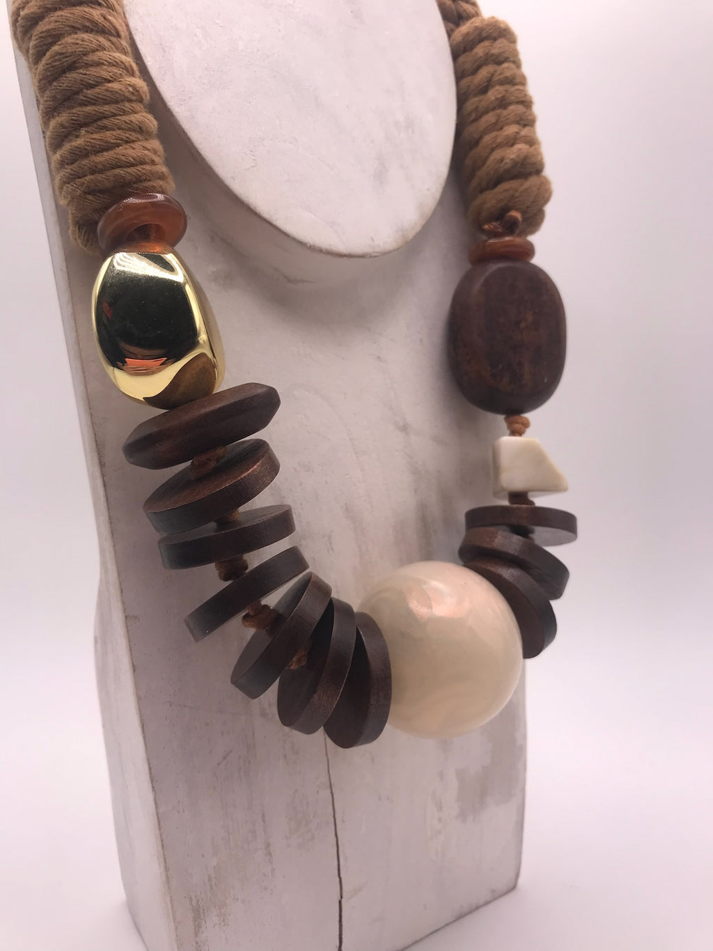 Colar artesanal de corda castanha e peças geométricas de madeira, bijuteria étnica boémia com esfera bege e detalhe dourado.