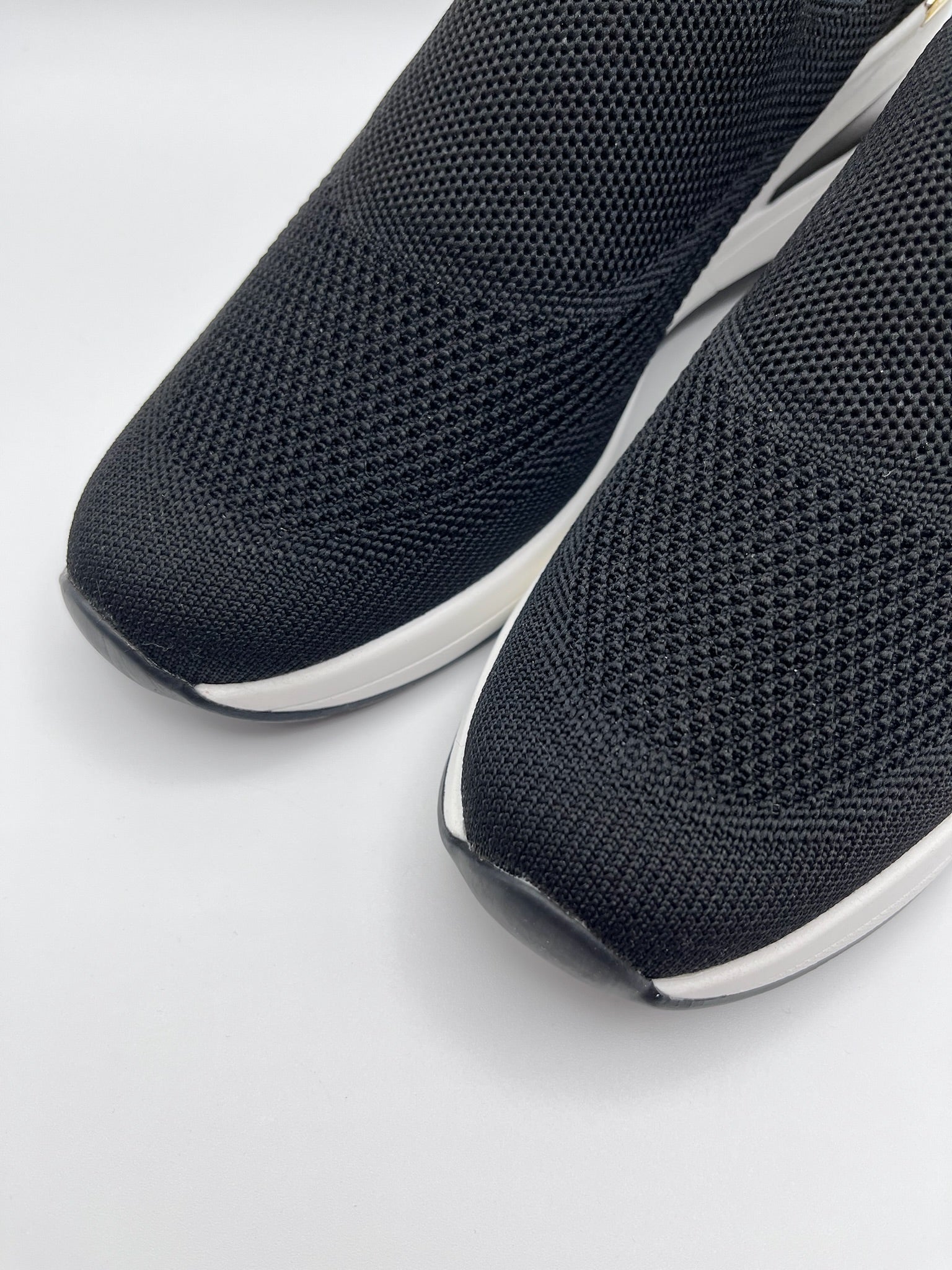 Sapatilhas Xti slip-on sem atacadores pretas com cunha e detalhe dourado; ténis de senhora em malha elástica confortáveis; calçado feminino moderno e leve para o dia a dia