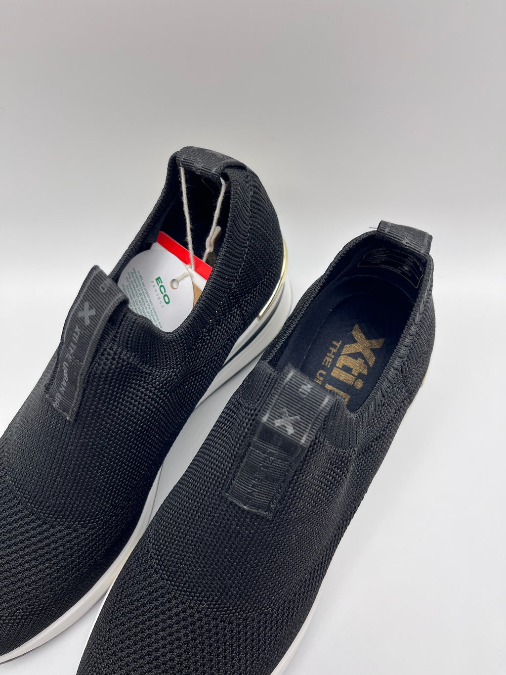 Sapatilhas Xti slip-on sem atacadores pretas com cunha e detalhe dourado; ténis de senhora em malha elástica confortáveis; calçado feminino moderno e leve para o dia a dia
