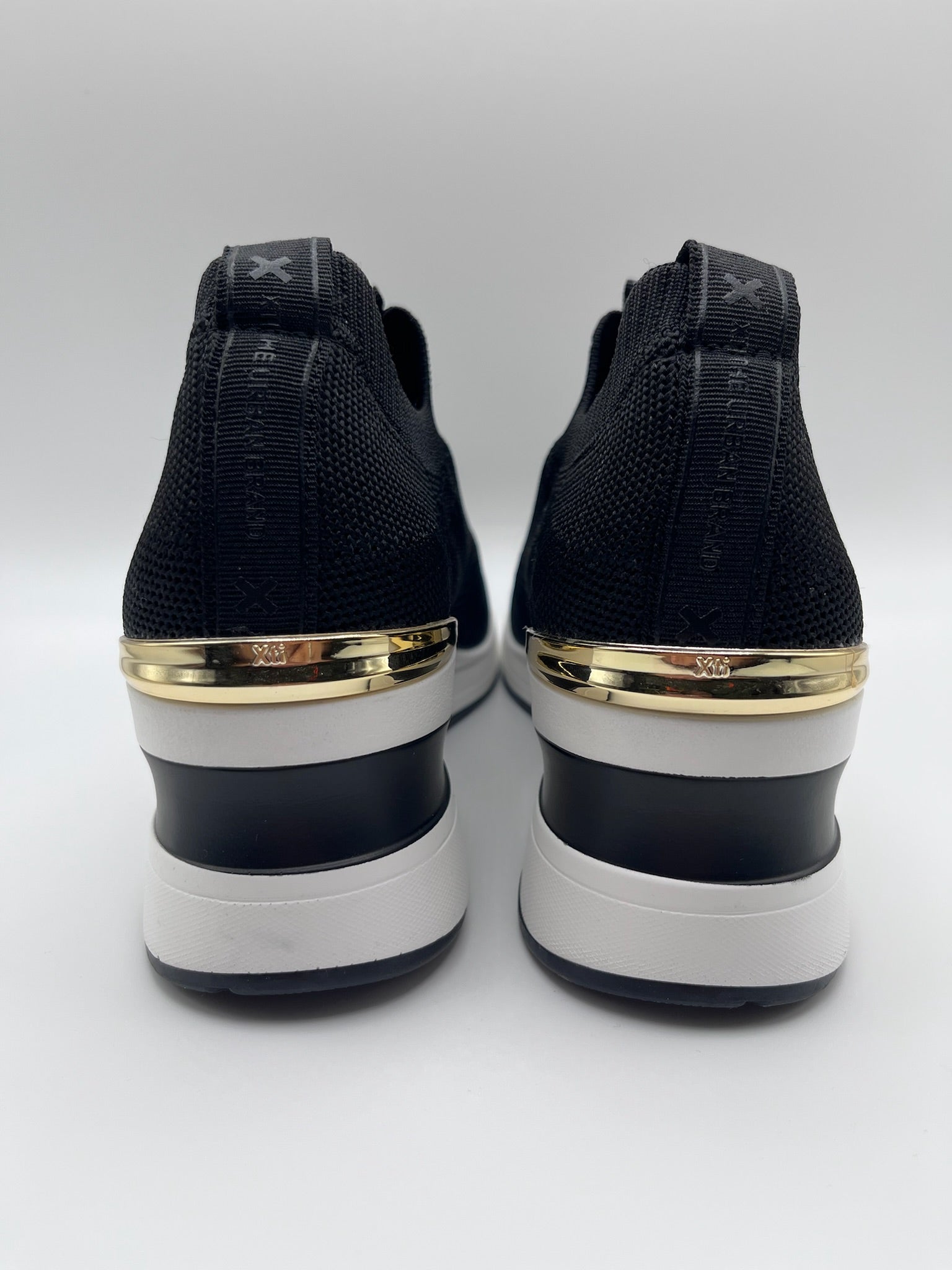 Sapatilhas Xti slip-on sem atacadores pretas com cunha e detalhe dourado; ténis de senhora em malha elástica confortáveis; calçado feminino moderno e leve para o dia a dia