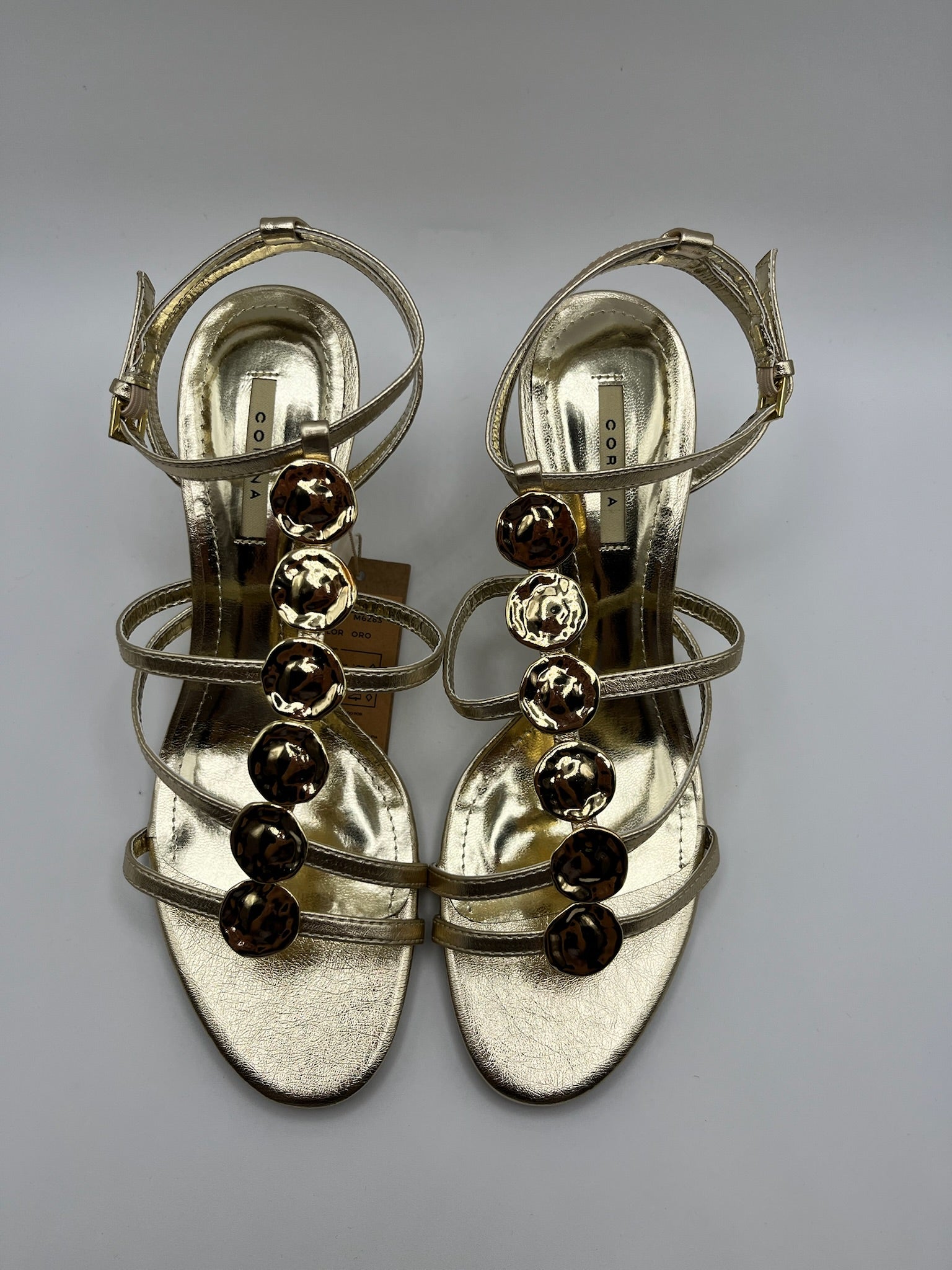 Sandália de Salto Alto Agulha Corina com Tiras Dourado Oro, Couro Sintético Metalizado, Detalhe Círculos de Metal, Festa Casamento Cerimónia Elegante Feminina